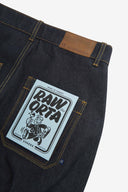 Close up of waist area of raw orta denim workwear pants in dark indigo. Clear view of waistline, back pocket with Uskees branding label and 'Raw Orta' cardboard pocket plaster.