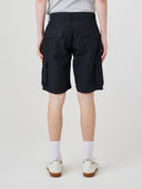 Bottom-half back view of male model wearing black 5023 men's ripstop cargo shorts with clear view of flapped back pockets, side cargo pockets and relaxed look.