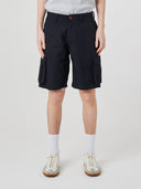 Bottom-half front view of male model wearing black 5023 men's ripstop cargo shorts with clear view of deep cargo front patch pockets.