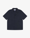 Front flat shot of Uskees dark blue Cuban short sleeve shirt for men. Clear view of corozo buttons, chest pocket and Uskees branding label.