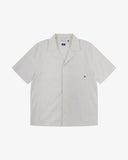 Front flat shot of Uskees off-white Cuban shirt for men. Clear view of corozo buttons, chest pocket and Uskees branding label.