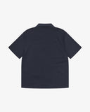 Reverse flat view of dark blue fabric short sleeve shirt from Uskees showing relaxed silhouette.
