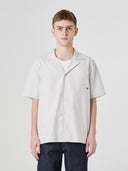 Top-half view of model wearing an Uskees off-white Cuban shirt demonstrating relaxed, casual fit.