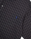 Close-up of an Uskees eastlands blue timber leah plaid shirt with small blue brand logo tab on the pocket. 