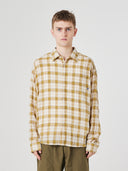 Front view of a male model wearing an Uskees sand pebble plaid lumberjack shirt for men.