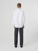 Reverse view wearing Uskees white men's Oxford shirt, paired with Uskees dark grey pants.