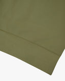 Closer view view of the discreet brand logo on ribbed hem of the Uskees herb-green organic heavyweight cotton 7005 jersey sweatshirt.