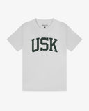 Full flat view of white organic cotton signature T-shirt for men, showing the dark green varsity inspired 'USK' logo on the chest and the Uskees branding labels on the neck and hem.