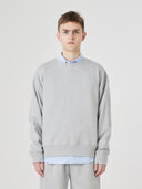 Front view close up male model shot of Uskees grey marl Champ Sweatshirt for men, paired with matching pants.