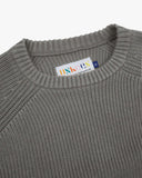 Front close up view of Uskees dark grey sweater for men with focus on the ribbed knit, crew neck and brand label.
