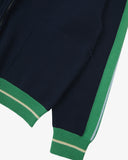 Close up view of an Uskees navy blue zip front track jacket with green accents, presented on a white background.