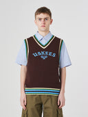 Front view of a male model wearing a brown sleeveless sweater vest with 'USKEES' branding on a light gray background.