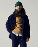 Man wearing Alderney crew neck jumper in Scottish new wool from Uskees. Paired with midnight blue cord suit.