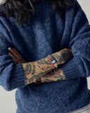 Close-up of model wearing Uskees 7021 Skye lambswool sweater in sapphire blue.
