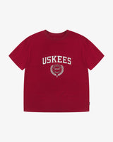 Full flat view of the Uskees red organic cotton T-shirt for men, showing the brand graphics on front and loose silhouette.