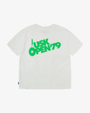 Back view of the Uskees white organic cotton jersey T-shirt showing the bold tennis open graphics in green and the loose silhouette.