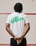 Back view of model wearing the Uskees white organic cotton T-shirt for men, showing the loose fit and bold 'USK Open 79' brand graphics.