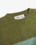 Close-up of a green and blue men's sweater with an Uskees brand label at the neck on a white background.