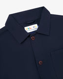Close-up view of 3001 midnight blue, buttoned organic cotton overshirt from Uskees showing corozo buttons, brand label, collar and hanging hoop.