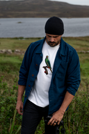 Male model holding binoculars wearing an Uskees white t-shirt with parakeet graphic print on chest and a blue overshirt.